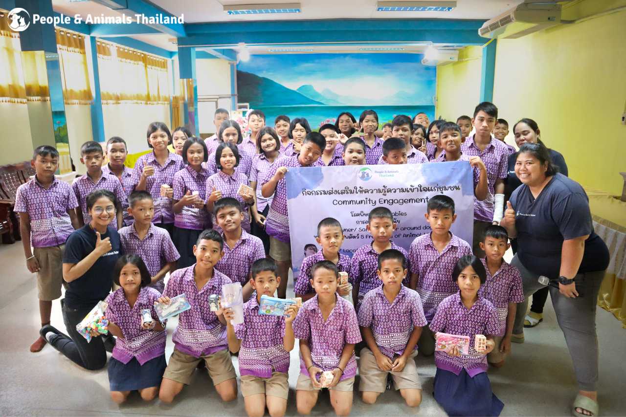 The team posing with the students at the education day